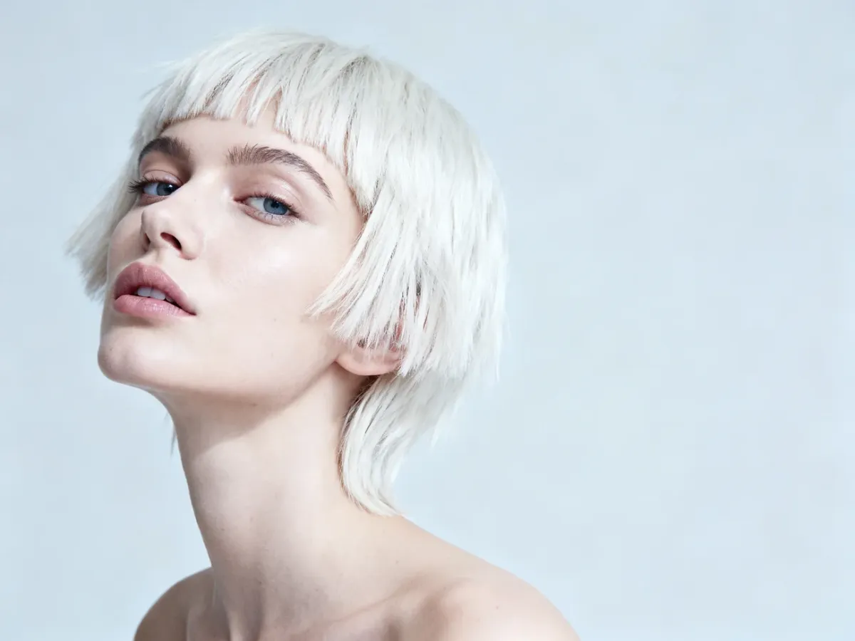 Kobieta z nowoczesną platynową fryzurą pixie cut